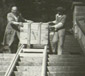 ERR depot of Neuschwanstein, Germany—Two workers sliding a crate of looted objects down a wooden ramp for transfer to Lager Peter (Aussee, Austria), 12 June 1944.